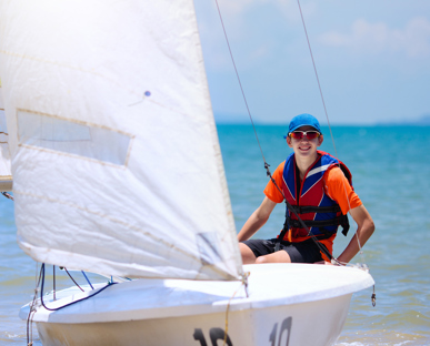 Smiling Adolescent Boy Steering A Dingy
