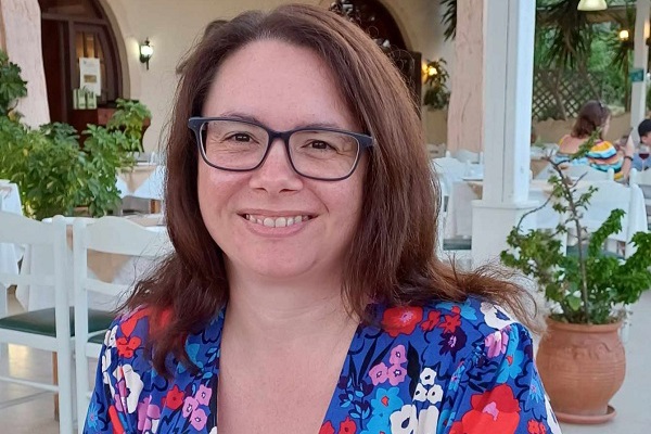 Close up of a lady in a summer dress smiling outside a restaurant