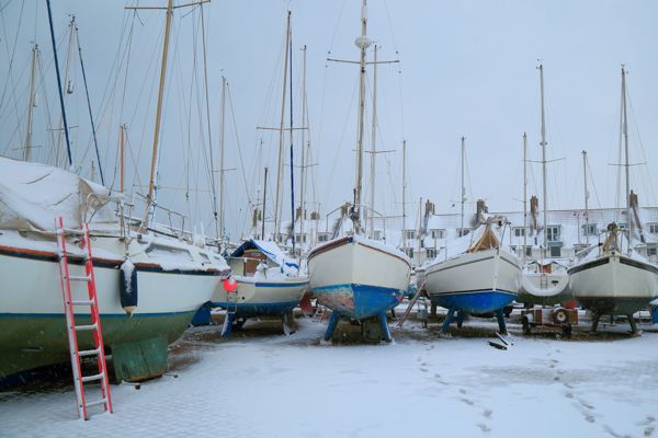 Boats lined up in a row in snowy weather